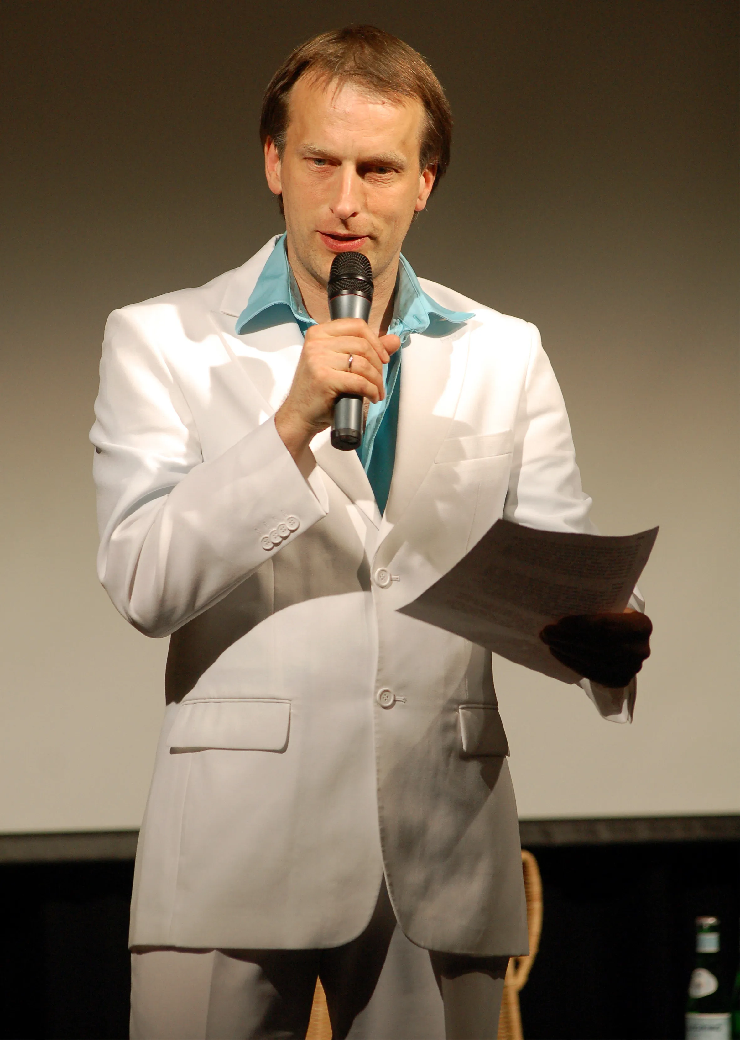 Thommi Baake als Moderator im weißen Anzug